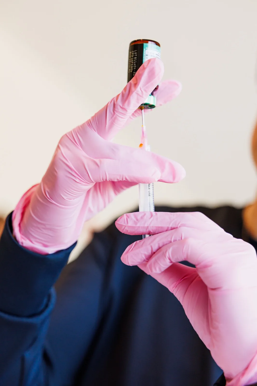 Gloved hands drawing a vitamin add-on into a syringe