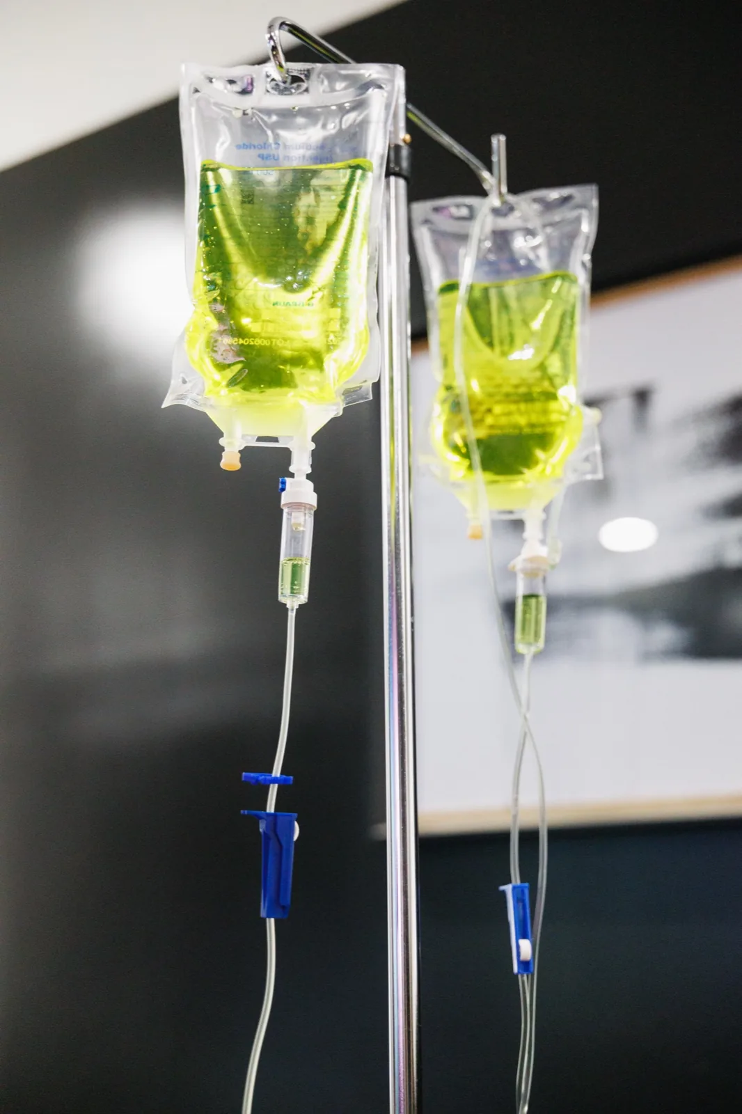 Two IV bags hanging from a pole in a living room